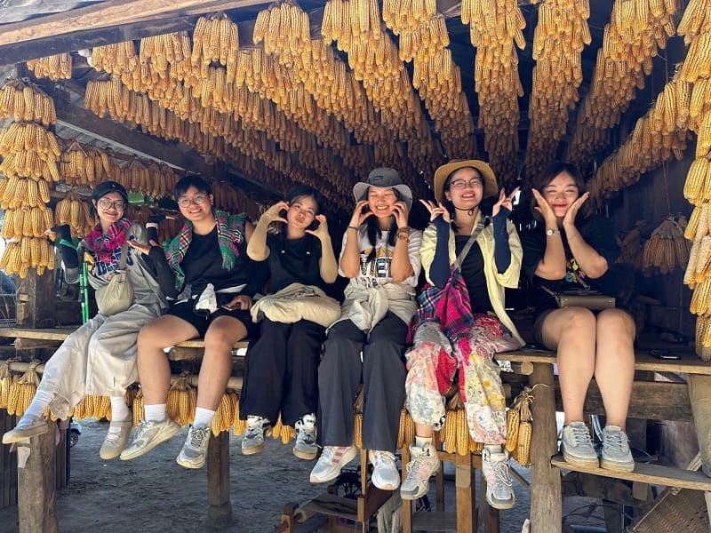 L'équipe d'Horizon Vietnam Travel sous des épis de maïs séchés, lors d'un repérage dans le Nord du Vietnam