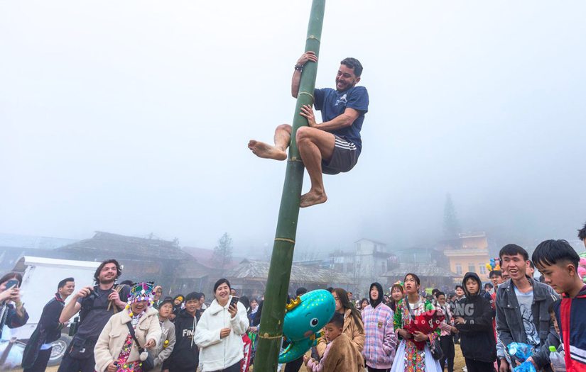 Des touristes étrangers découvrent avec enthousiasme la fête de Gầu Tào