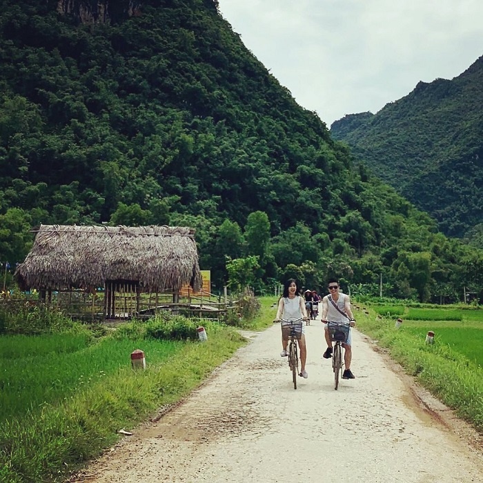 Besucher auf dem Fahrrad im Dorf Lac in Mai Chau