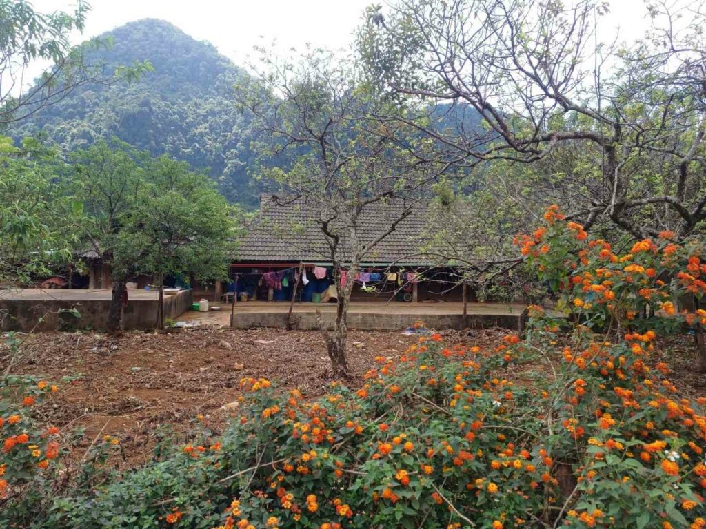 Traditionelles Haus im Dorf Thung Mai umgeben von Bergen