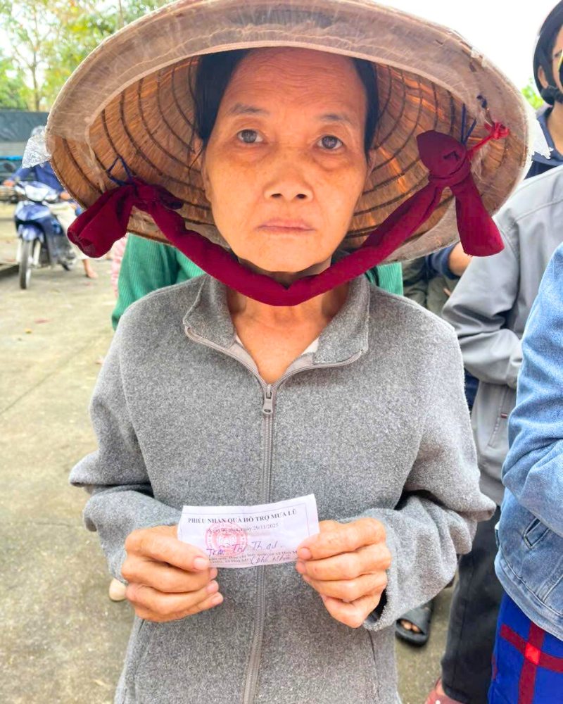 Une habitante sinistrée tenant son coupon pour recevoir l’aide d’urgence