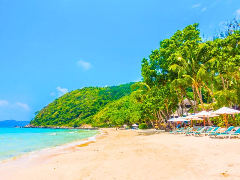Plage d'An Bang en mai : Sable blanc, eau calme et ciel ensoleillé, parfait pour une journée de détente au bord de l'océan