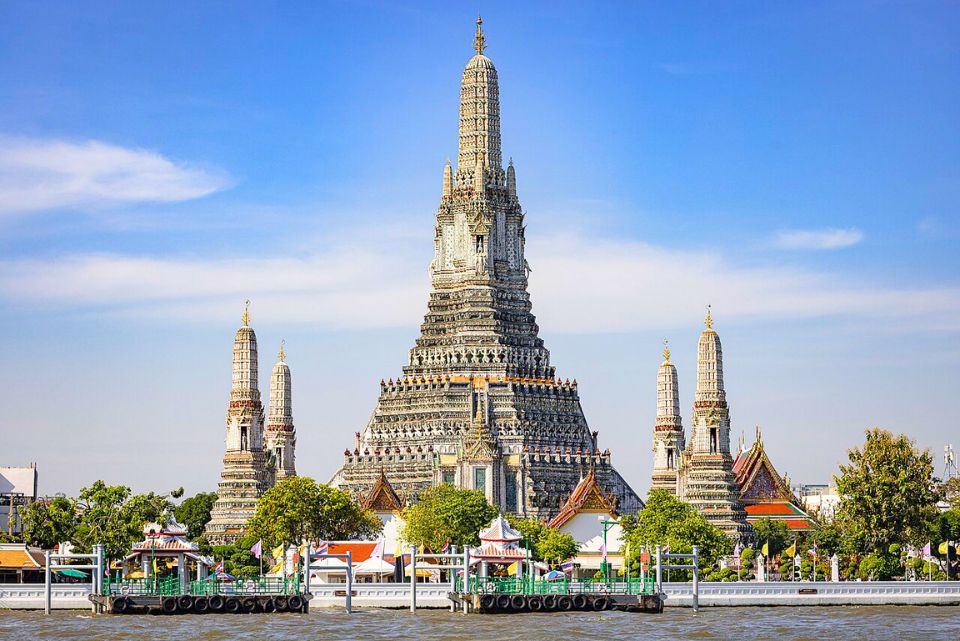 Wat Arun, temple emblématique de Bangkok, se distingue par sa tour majestueuse ornée de porcelaines, scintillant au bord du fleuve Chao Phraya