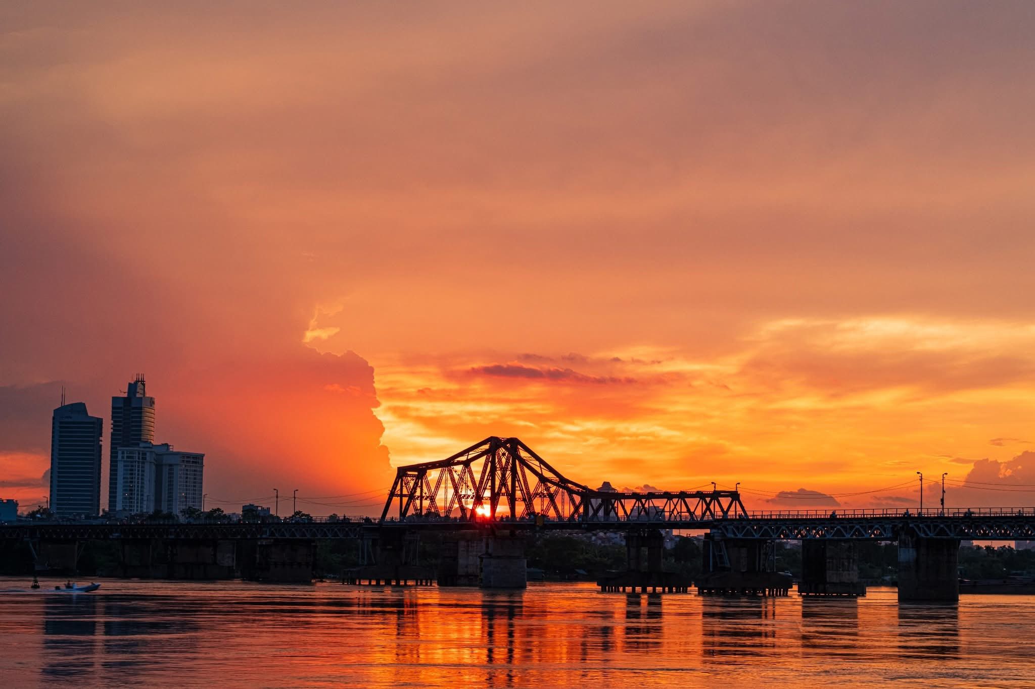 Vue sur le fleuve Rouge depuis le Pont Long Biên au coucher du soleil — l'un des panoramas les plus saisissants de la capitale