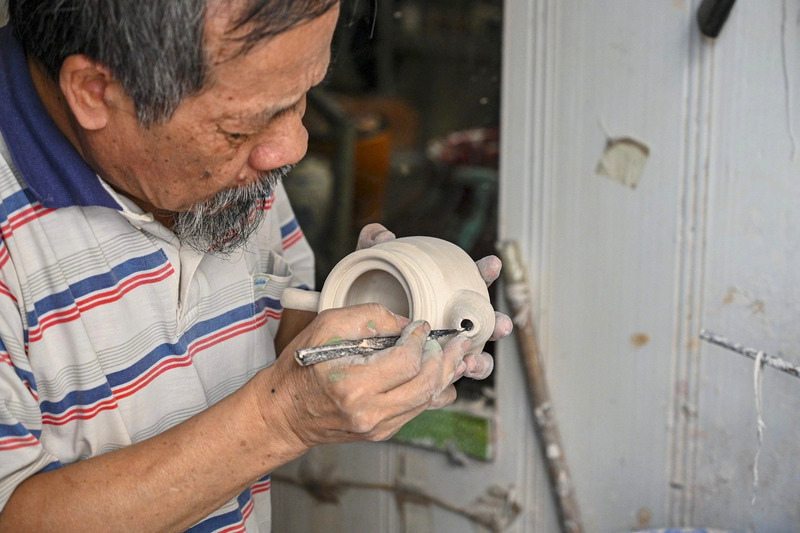 L’artisan Phạm Ngọc Huy, l’un des gardiens du savoir-faire traditionnel de la céramique de Bat Trang. Photo : Dantri