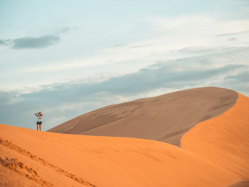 Voyageuse au sommet des dunes rouges de Mui Ne au Vietnam