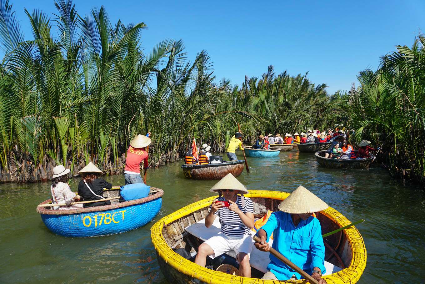 Touristes en barque ronde dans la forêt de cocotiers de Bay Mau