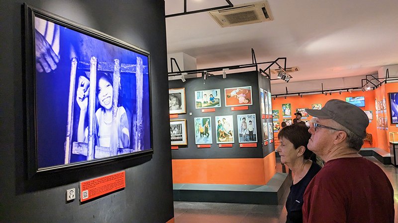 Visiteurs explorant une salle d’exposition du Musee des Vestiges de la Guerre a Saigon