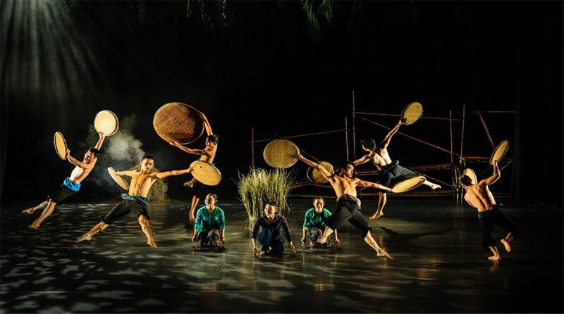Spectacle À Ố Show à l'Opéra de Saïgon, danseurs acrobates en plein saut avec paniers et plateaux en bambou sur scène