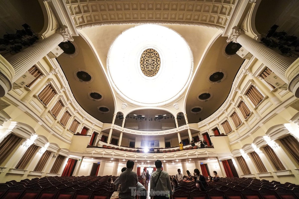 Intérieur de l'Opéra de Saïgon, vue grand angle depuis le parterre montrant le plafond en coupole, les balcons et la scène, décoration ivoire et or
