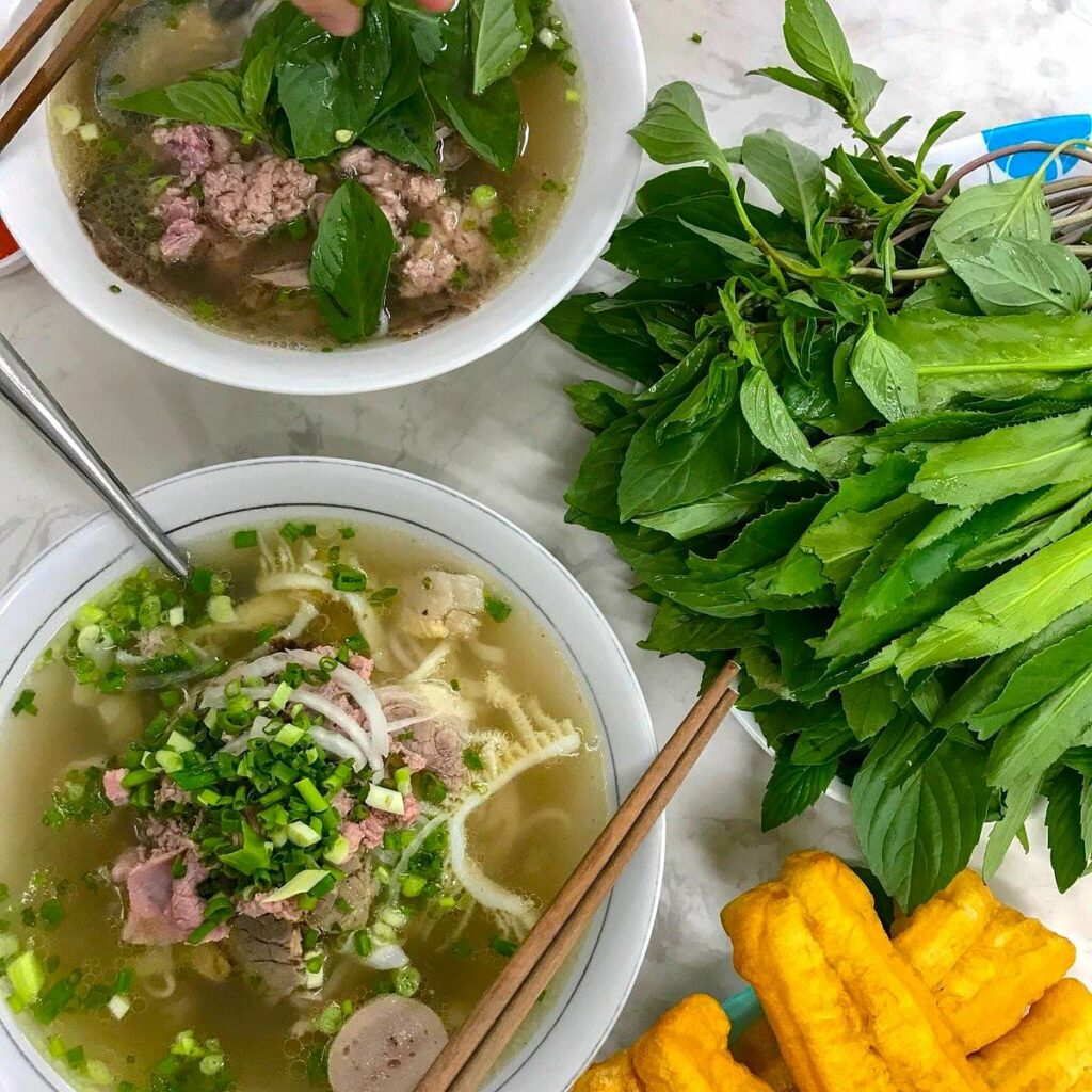 Le bol fumant de Pho Hoa Pasteur, son bouillon doré et sa montagne d’herbes fraîches.