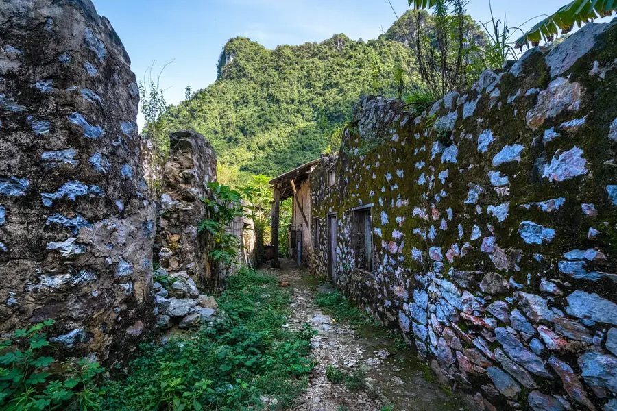 Ruelle entre les murs de pierre centenaires du village de Khuoi Ky