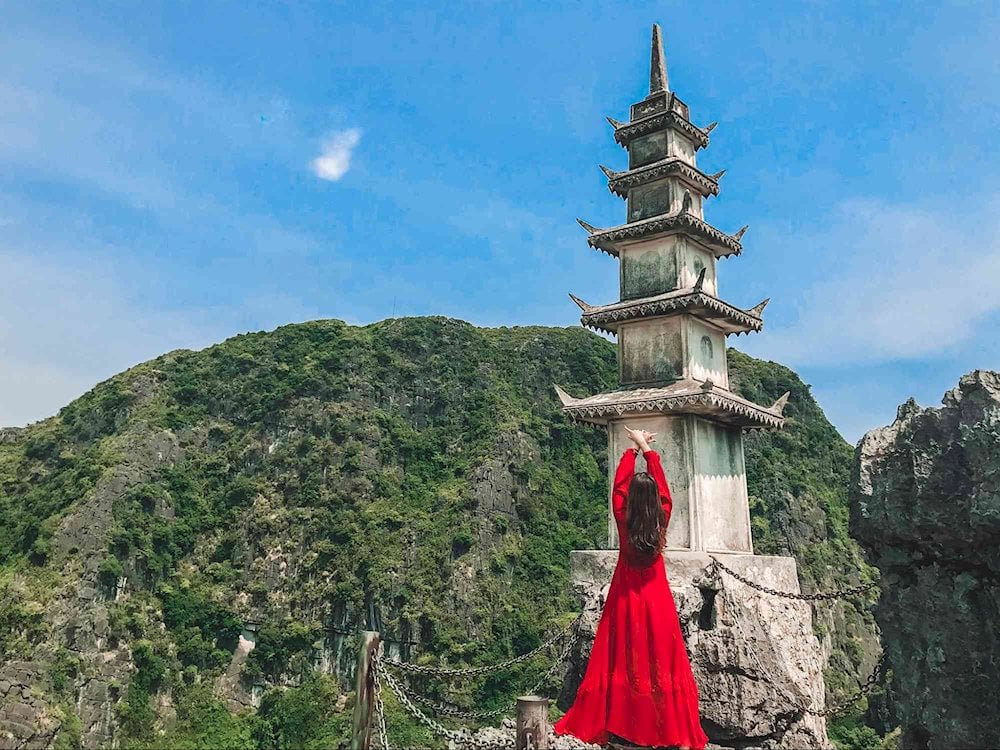 Visiteuse en tenue traditionnelle au sommet de Hang Mua