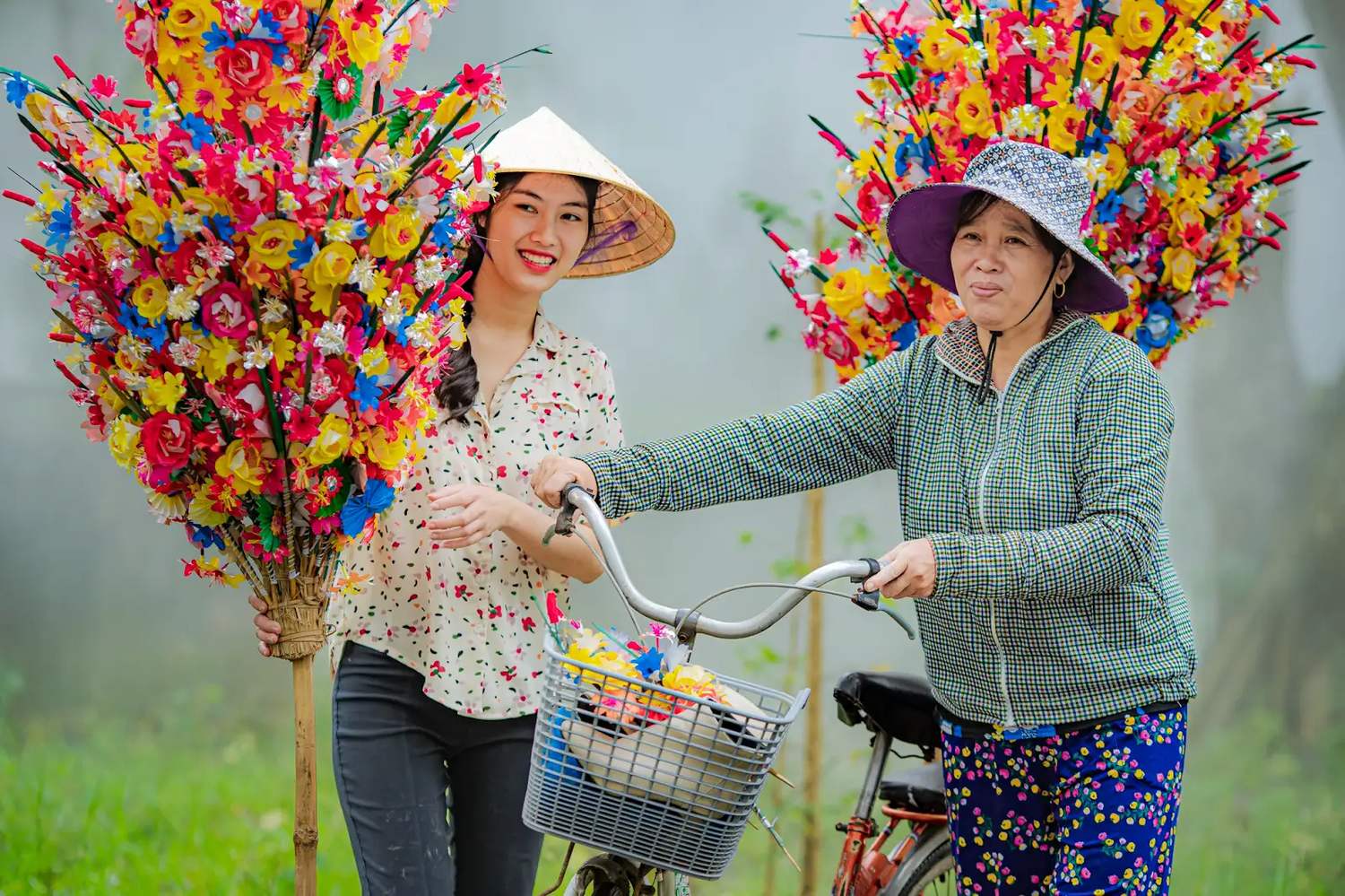 Visiteuse en chapeau conique parmi les fleurs en papier de Thanh Tien