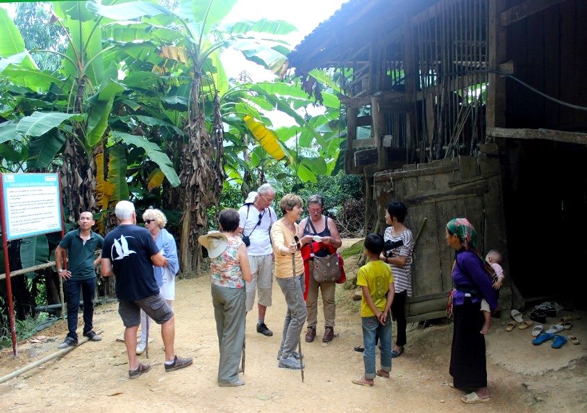 Voyageurs accueillis par une habitante du village de Khuoi Khon