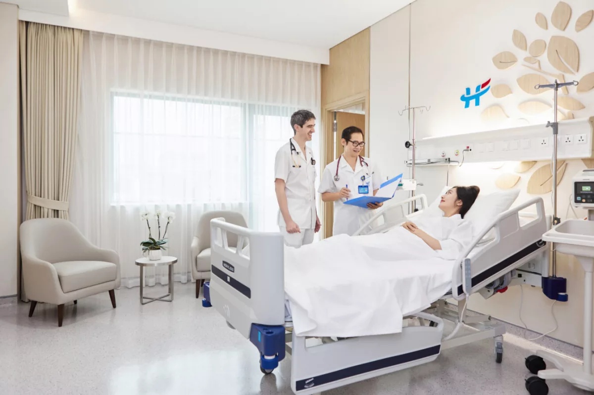 Médecins consultant le dossier d'un patient dans une chambre d'hôpital internationale au Vietnam assurance voyage Vietnam