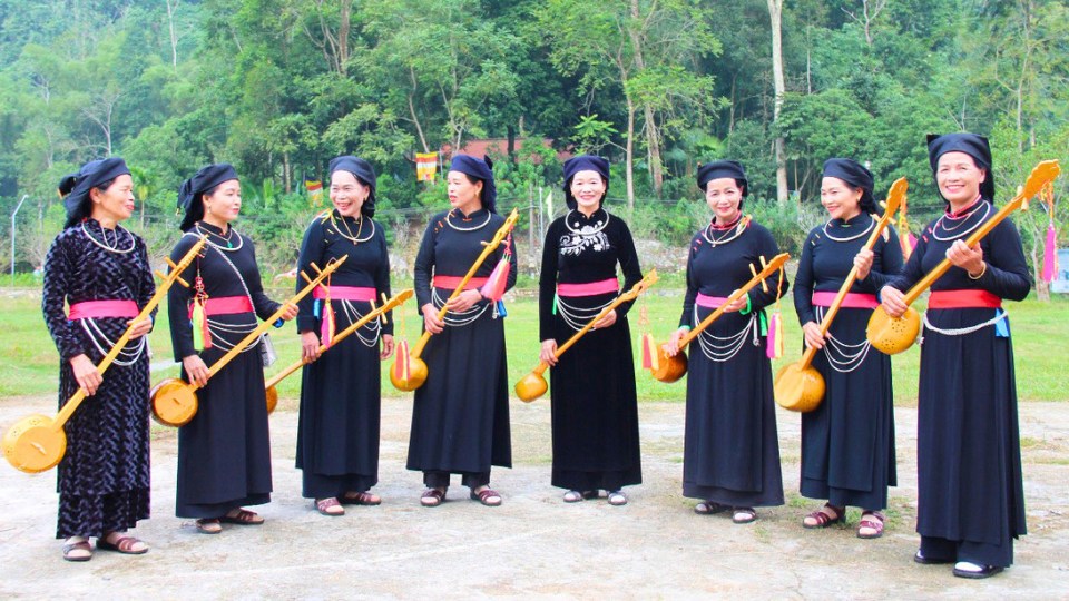 Femmes de l'ethnie Tay en costume traditionnel noir, jouant du dan tinh
