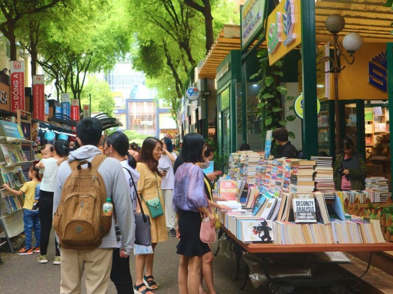 Visiteurs consultant des livres en anglais sur un stand extérieur de la rue du livre Nguyen Van Binh