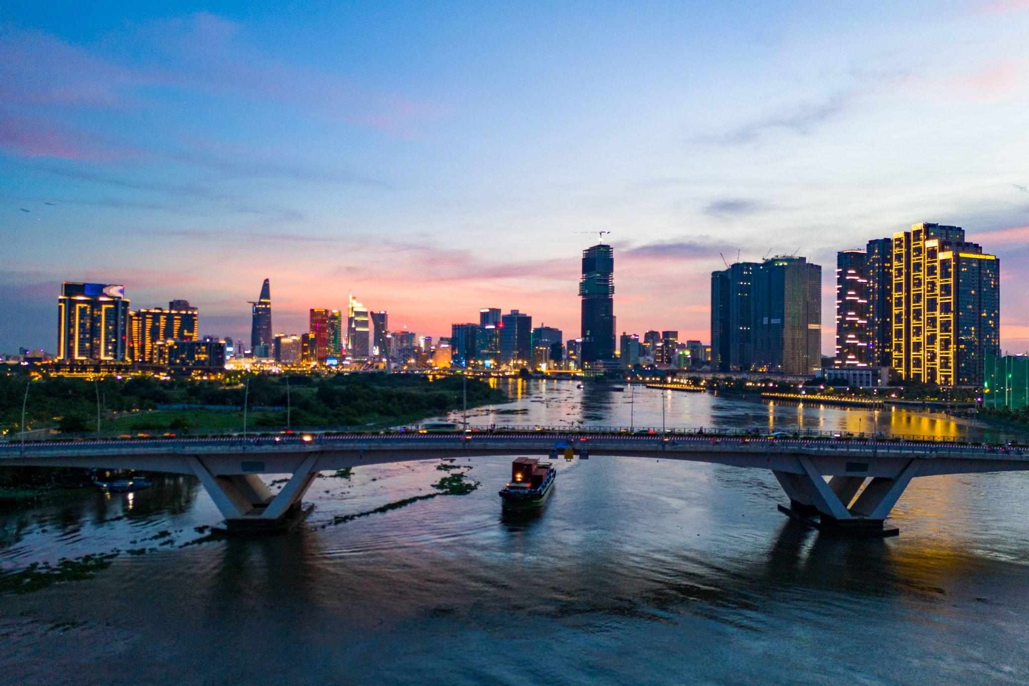Pont sur la rivière Saigon au crépuscule, près du nouveau quartier en face du centre-ville