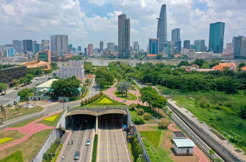 Vue aérienne du parc et de l'entrée du passage souterrain, avec la skyline de Ho Chi Minh-Ville au loin