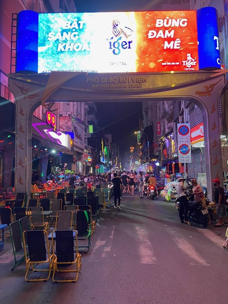 Entrée de la rue piétonne Bui Vien en début de soirée avec terrasses installées