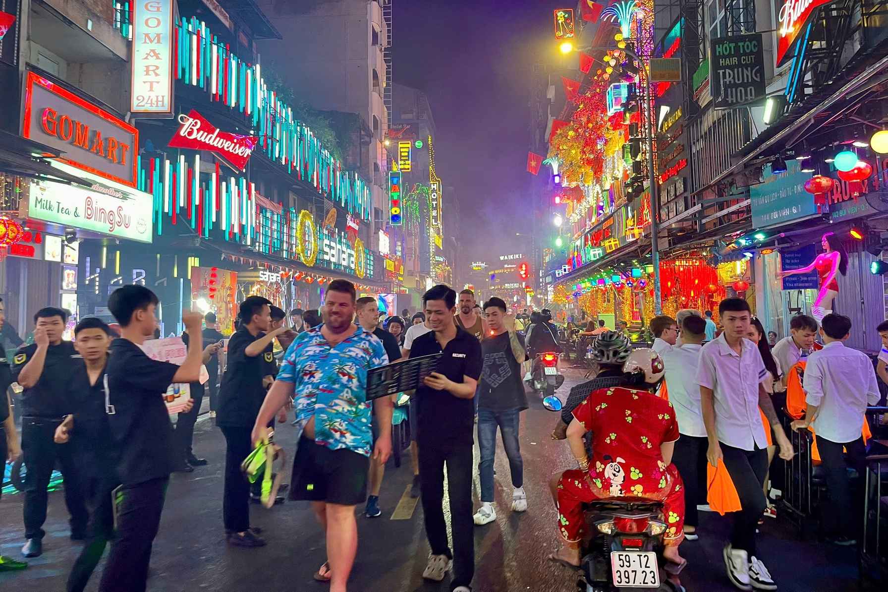 Foule de visiteurs devant les enseignes colorées de la rue Bui Vien la nuit