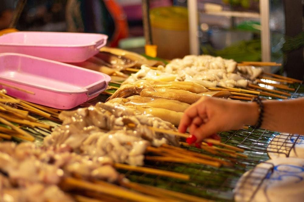 Brochettes de calamars grillées sur un stand de street food à Bui Vien