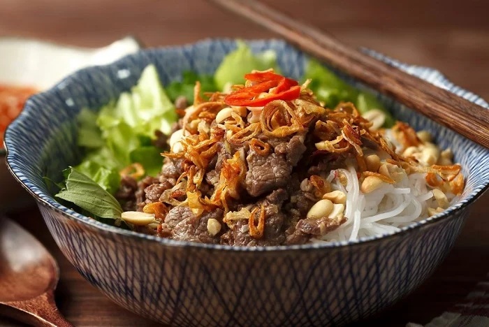 Bol de bun bo Nam Bo garni de boeuf sauté, cacahuètes concassées et échalotes frites