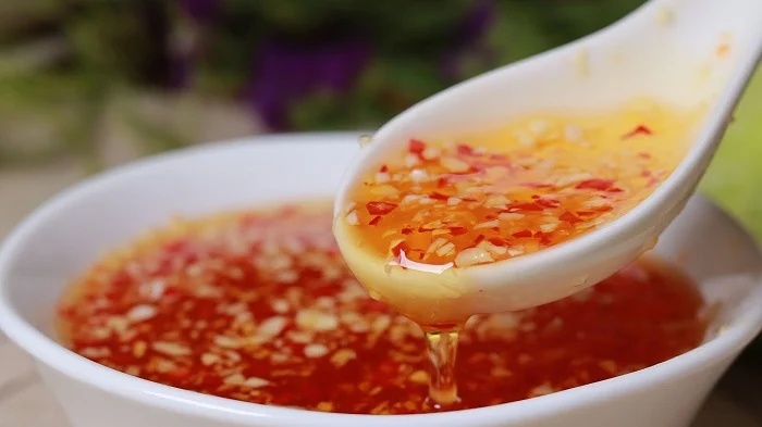 Sauce nuoc mam sucrée-salée-acidulée versée sur les vermicelles et le boeuf sauté