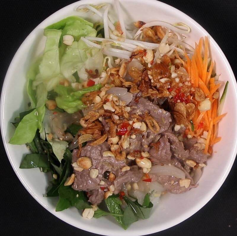 Bol de vermicelles vietnamiens vu de dessus avec bœuf, cacahuètes et légumes frais