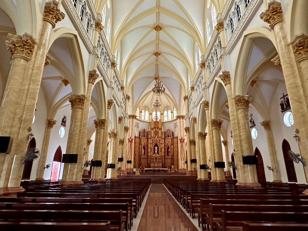 Intérieur d'une église de style gothique au Vietnam, avec voûtes ogivales et vitraux