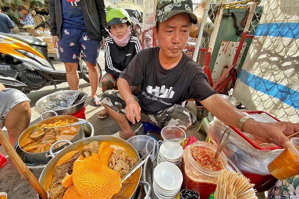 Vendeur de rue préparant des spécialités culinaires au marché de Binh Tay