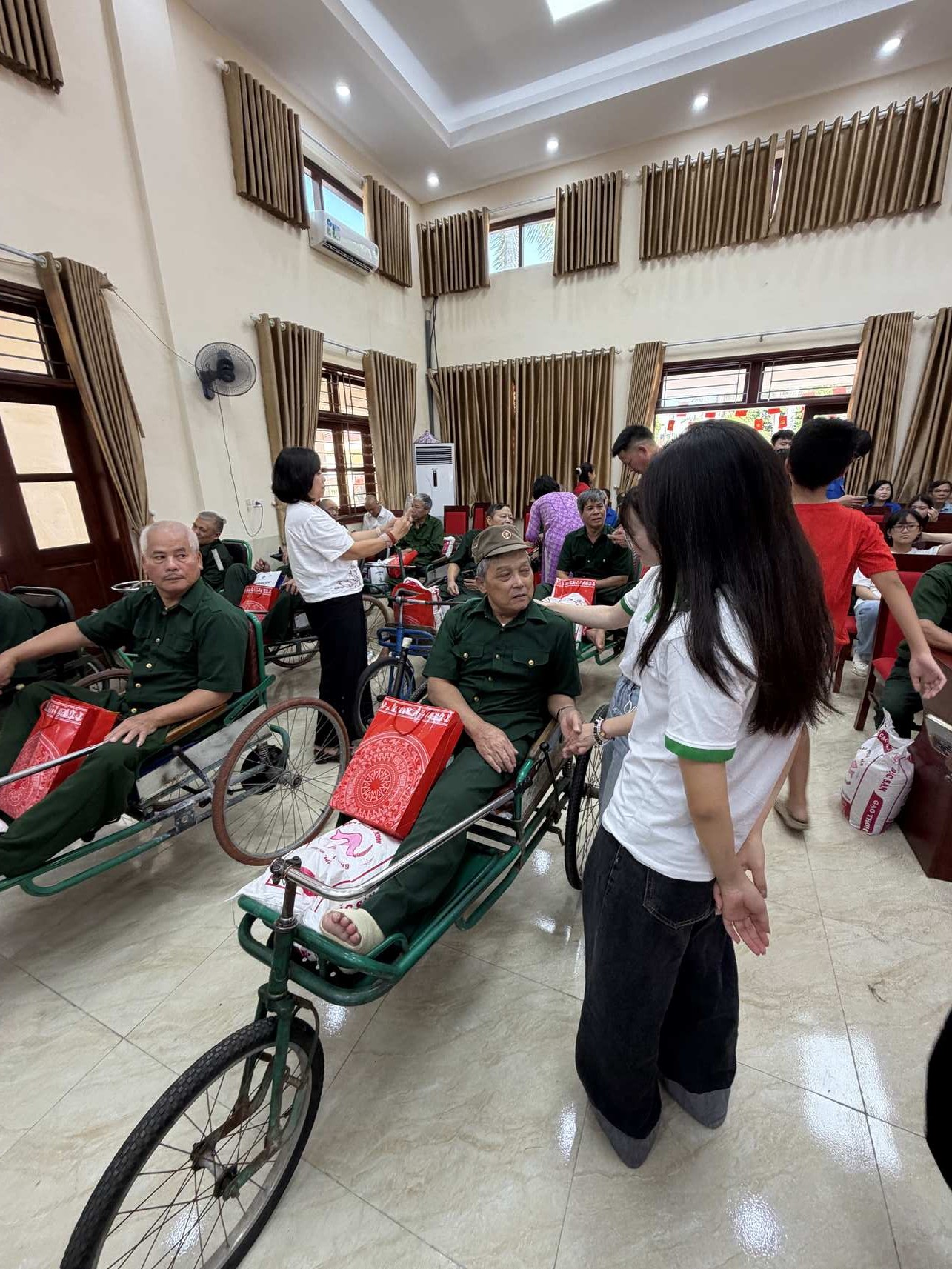 Une bénévole d'Horizon Vietnam Travel remet un cadeau à un ancien combattant du centre de Duy Tiên