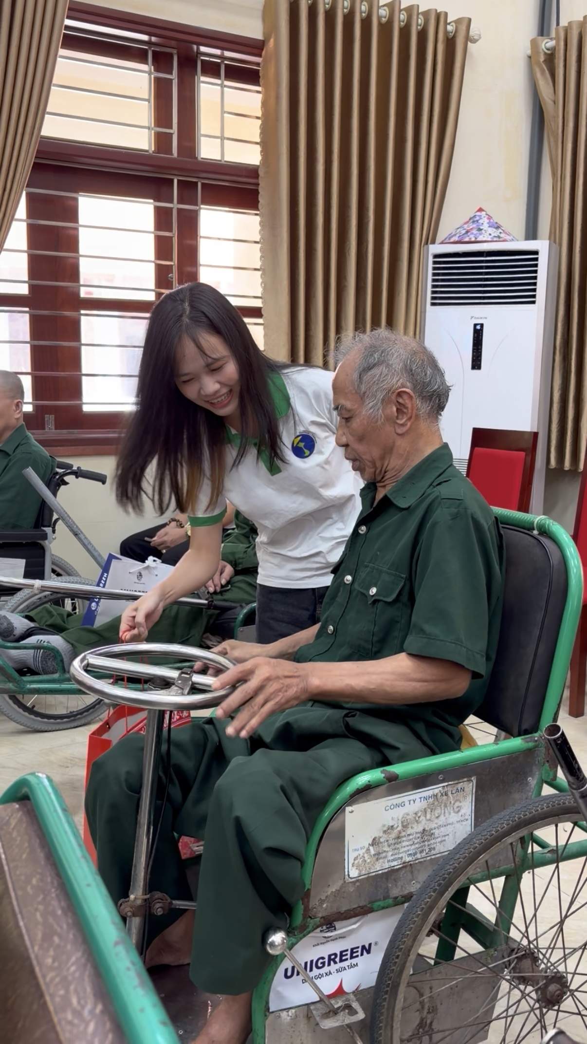 Une bénévole aide un ancien combattant à mobilité réduite avant la distribution des cadeaux
