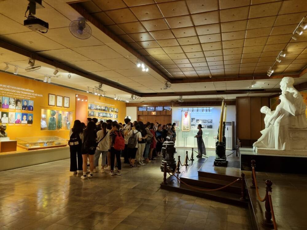 Salle d'exposition du musée des Femmes du Sud Vietnam avec un groupe de visiteurs