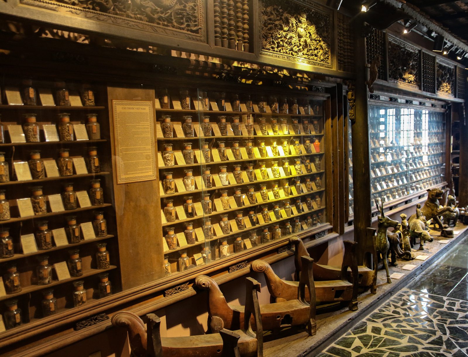 Long comptoir de pharmacie traditionnelle en bois orné de tiroirs, musée FITO