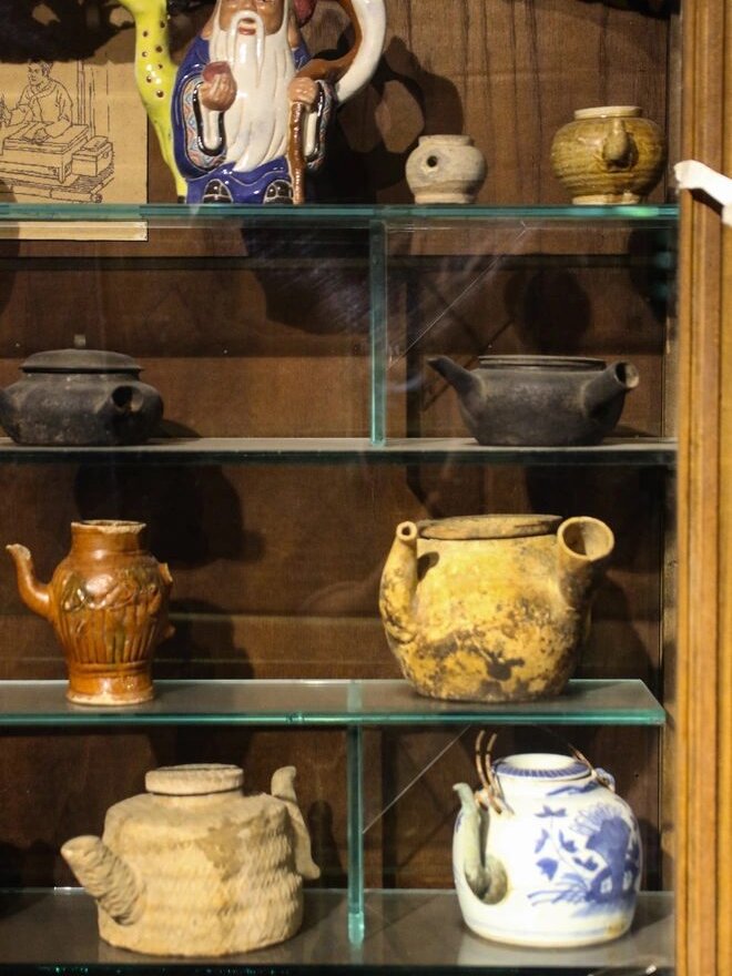 Vitrine de figurines et théières en céramique ancienne, musée FITO