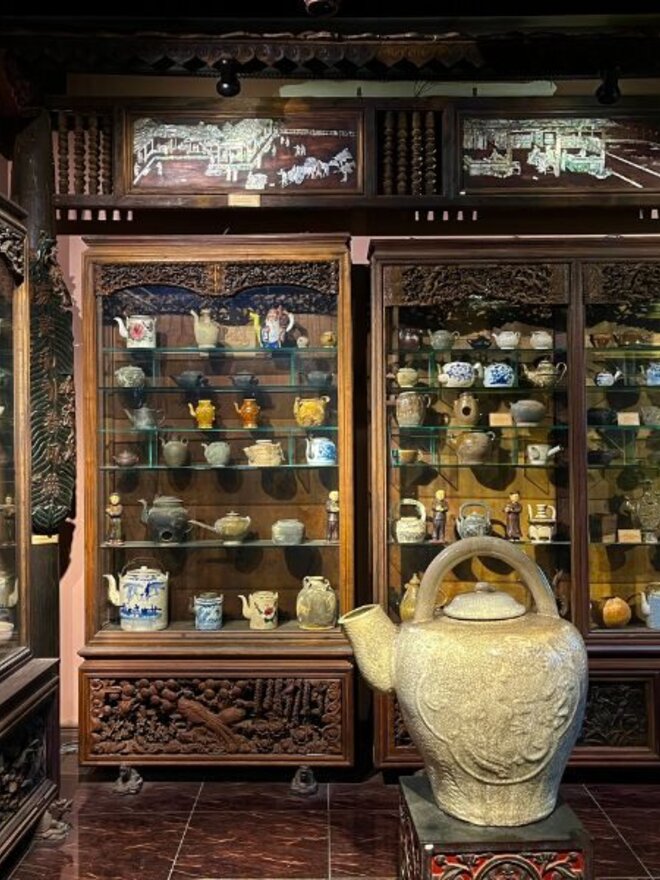 Grandes vitrines en bois sculpté présentant une collection de théières anciennes, musée FITO