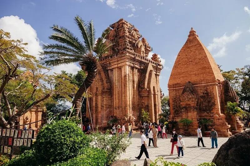Visiteurs se promenant devant les tours Po Nagar à Nha Trang