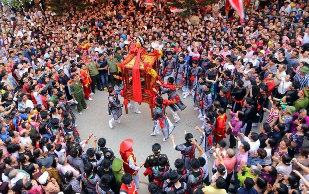 Procession du palanquin entourée de la foule lors d'une fête de village au Vietnam