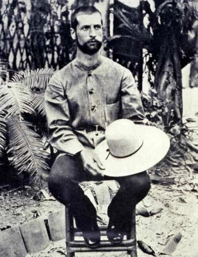 Alexandre Yersin sitzend, den Hut in der Hand