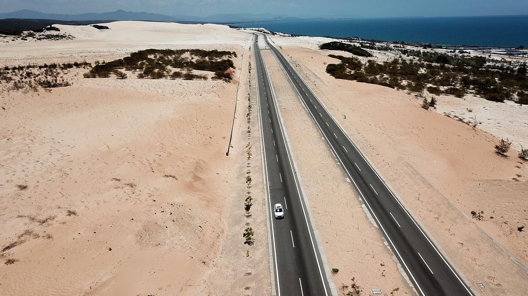 Vue aérienne de la route longeant les dunes blanches de Bau Trang jusqu'à la mer