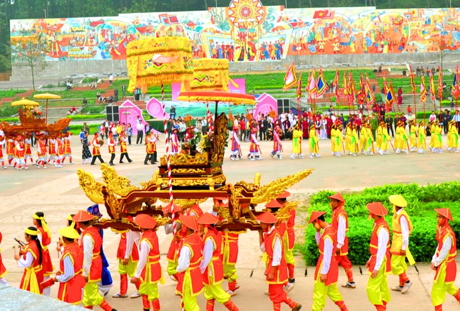 Procession traditionnelle avec des participants en costume portant un palanquin lors d’une cérémonie dédiée aux rois Hung à Phu Tho.