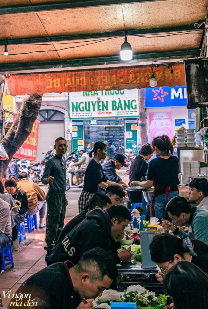 Repas de rue animé à midi dans une échoppe vietnamienne