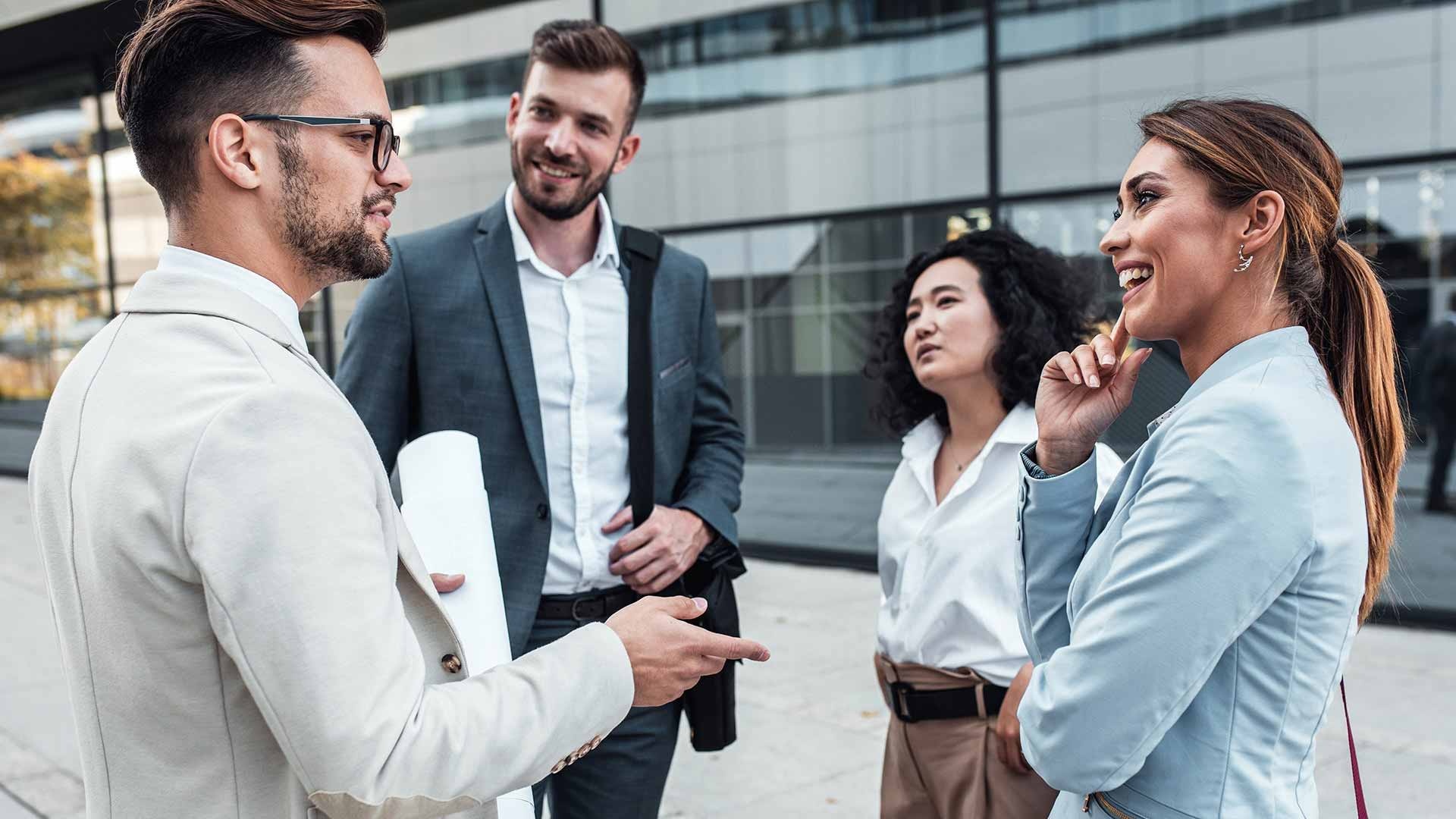 Des professionnels français discutant de façon directe devant un immeuble de bureaux