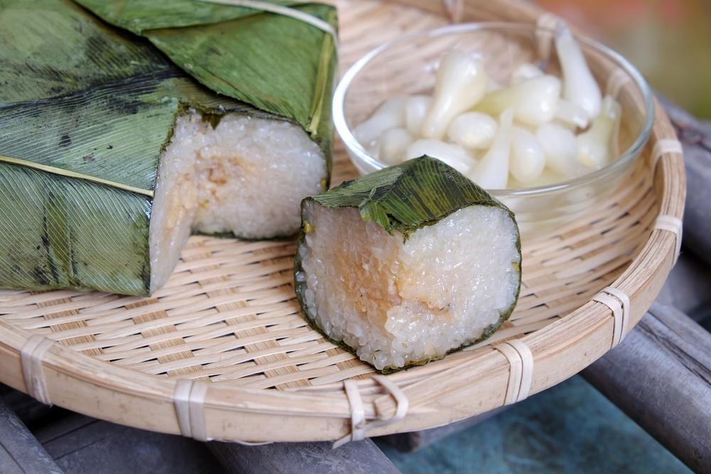 Part de banh chung dégustée avec des légumes marinés, un accompagnement traditionnel du Têt