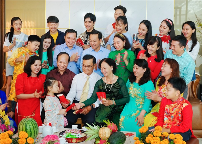 Une grande famille vietnamienne réunie pour échanger des enveloppes rouges lors du Têt