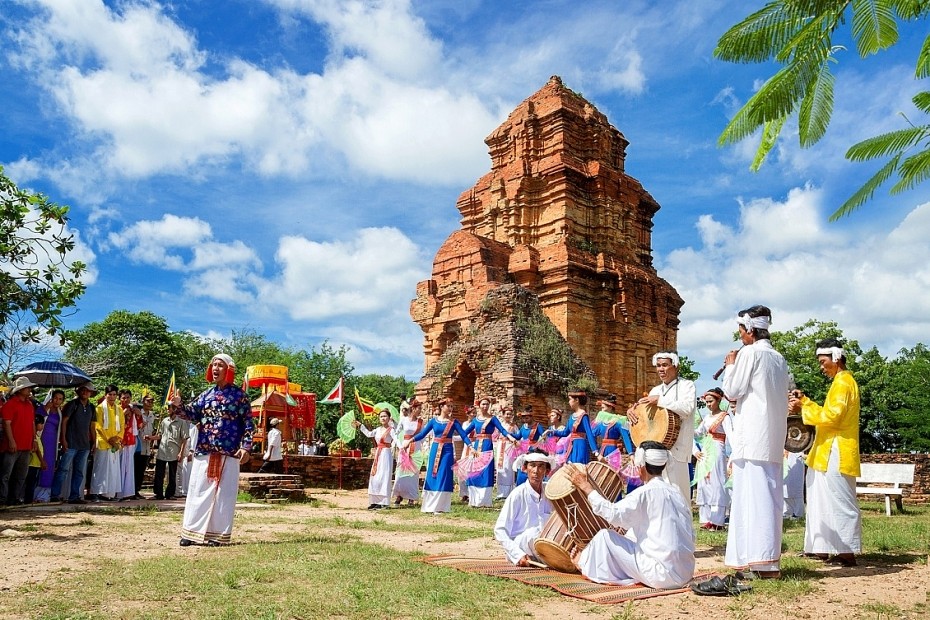 Cham-Musiker und -Tänzer vor einem Backsteinturm nahe Phan Rang