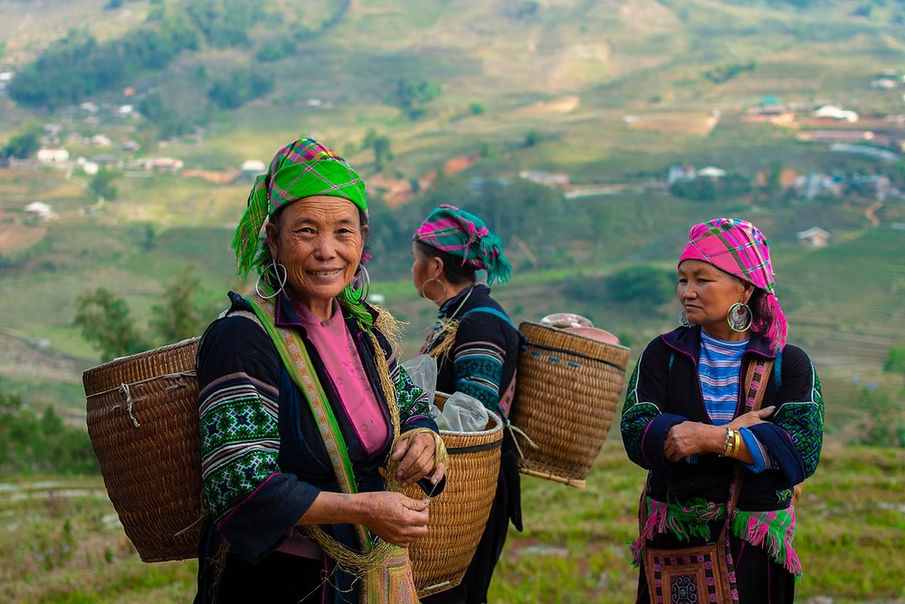 Hmong-Frauen in traditioneller Tracht mit Weidenkörben in der Nähe von Sapa