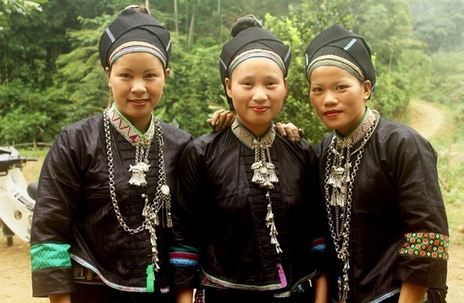 Drei junge Nung-Frauen in traditioneller schwarzer Tracht mit Silberschmuck